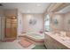 Well-lit main bathroom featuring a shower, bathtub, large mirror, and vanity at 621 High Point Dr, Mount Dora, FL 32757