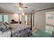 Spacious main bedroom featuring a ceiling fan, floral wallpaper and an en-suite bathroom at 621 High Point Dr, Mount Dora, FL 32757