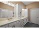 Bathroom with double sinks, white cabinets, granite countertops, and modern fixtures at 6243 Danielson Loop, The Villages, FL 32163