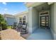 Inviting covered entry with rocking chairs, a bench, and brick paver porch at 6243 Danielson Loop, The Villages, FL 32163