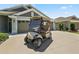 A golf cart sits in the driveway, ready for a ride around the community at 6243 Danielson Loop, The Villages, FL 32163