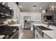 Bright kitchen showcasing stainless steel appliances, quartz countertops, a farm sink, and gray backsplash at 6243 Danielson Loop, The Villages, FL 32163
