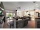 Open floor plan featuring the living room, kitchen, and dining area. Large sectional sofa and patio access at 6243 Danielson Loop, The Villages, FL 32163