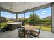 Outdoor dining set on a screened-in patio with a hot tub and backyard views at 6243 Danielson Loop, The Villages, FL 32163