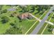 A perfectly manicured property features mature landscaping, long driveway, and fenced backyard with a firepit at 7629 Lake Angelina Dr, Mount Dora, FL 32757