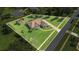An aerial view of the perfectly manicured lawn, fenced in yard, and outdoor firepit seating area at 7629 Lake Angelina Dr, Mount Dora, FL 32757