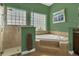 Well-lit bathroom featuring a glass shower, soaking tub, and green walls at 7629 Lake Angelina Dr, Mount Dora, FL 32757
