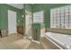 Modern bathroom featuring a shower, soaking tub, green walls, and tiled floors at 7629 Lake Angelina Dr, Mount Dora, FL 32757