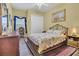 Charming bedroom with a floral comforter, wood floors, a ceiling fan, and natural light at 7629 Lake Angelina Dr, Mount Dora, FL 32757