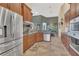 Spacious kitchen open to dining area features stainless steel appliances and wood cabinetry at 7629 Lake Angelina Dr, Mount Dora, FL 32757