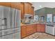Spacious kitchen featuring stainless steel refrigerator and wooden cabinetry at 7629 Lake Angelina Dr, Mount Dora, FL 32757