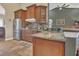 Well-lit kitchen features granite counters, stainless steel refrigerator, and wooden cabinets at 7629 Lake Angelina Dr, Mount Dora, FL 32757