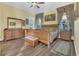 Bright main bedroom with wood floors, a ceiling fan, and beautiful natural light at 7629 Lake Angelina Dr, Mount Dora, FL 32757