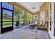 A cozy screened-in porch with comfortable seating and a ceiling fan, perfect for enjoying the outdoors at 7629 Lake Angelina Dr, Mount Dora, FL 32757