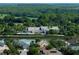 Elevated view showcasing a community center, swimming pool, lakefront homes, and lush greenery at 7873 Crosswinds Way, Mount Dora, FL 32757