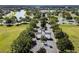 Stunning aerial view of a gated community entrance, featuring lush landscaping, serene lakes, and well-maintained roads at 7873 Crosswinds Way, Mount Dora, FL 32757