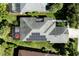 An aerial view showing solar panels on the roof of a home with screened-in pool area and landscaped yard at 7873 Crosswinds Way, Mount Dora, FL 32757