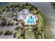 Aerial view of clubhouse, swimming pool, bocce ball and parking areas with water views at 7873 Crosswinds Way, Mount Dora, FL 32757