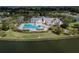 Gorgeous aerial view of community pool with lounge chairs and landscaping overlooking the lake at 7873 Crosswinds Way, Mount Dora, FL 32757