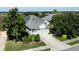Aerial view of a beautiful home with solar panels, a driveway, and a manicured lawn at 7873 Crosswinds Way, Mount Dora, FL 32757