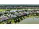 Overhead of a residential neighborhood featuring a mix of single-Gathering homes and a community lake at 7873 Crosswinds Way, Mount Dora, FL 32757