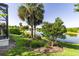 Picturesque backyard view of a serene pond, lush greenery, and mature trees offering privacy at 7873 Crosswinds Way, Mount Dora, FL 32757