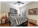 Serene bedroom featuring a queen bed, wood floors, and a picture window that lets in plenty of light at 7873 Crosswinds Way, Mount Dora, FL 32757
