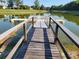 Well-maintained boat dock with weathered wood planks over calm waterfront at 7873 Crosswinds Way, Mount Dora, FL 32757