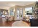 Elegant dining area with hardwood floors, large windows, and a stylish table setting at 7873 Crosswinds Way, Mount Dora, FL 32757