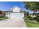 A lovely home with a gray two-car garage, meticulous landscaping and concrete driveway at 7873 Crosswinds Way, Mount Dora, FL 32757