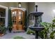 Inviting entryway showcasing double doors, manicured topiaries, and a charming water fountain at 7873 Crosswinds Way, Mount Dora, FL 32757