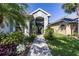 Charming home entrance with lush landscaping, walkway, and architectural details at 7873 Crosswinds Way, Mount Dora, FL 32757