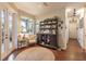 Inviting hallway with dark wood floors, decorative furniture, and natural light from a nearby window at 7873 Crosswinds Way, Mount Dora, FL 32757