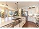 Bright kitchen features a large island with a stainless steel sink and modern lighting at 7873 Crosswinds Way, Mount Dora, FL 32757