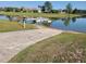 Community lake features boat dock with boat launch surrounded by lush landscaping and picturesque views at 7873 Crosswinds Way, Mount Dora, FL 32757
