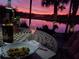 Outdoor dining area overlooking a serene lake during a beautiful sunset, perfect for evening relaxation at 7873 Crosswinds Way, Mount Dora, FL 32757