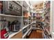 Organized pantry with white shelves, baskets, food storage, and espresso decor at 7873 Crosswinds Way, Mount Dora, FL 32757