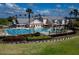 Expansive community pool with palm trees, lounge chairs, and a clubhouse in a landscaped setting at 7873 Crosswinds Way, Mount Dora, FL 32757