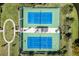 Aerial view of the community tennis and pickleball courts with blue playing surfaces and surrounding greenery at 7873 Crosswinds Way, Mount Dora, FL 32757
