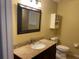 Bathroom features a granite countertop, framed mirror, decorative cabinet, and a toilet at 825 Mary Frank Ct, Mount Dora, FL 32757