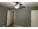 Neutral bedroom with a ceiling fan, closet, and two entry doors, offering a cozy retreat at 825 Mary Frank Ct, Mount Dora, FL 32757