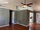 Open-concept living room with hardwood floors, ceiling fan, leading into the kitchen and dining area at 825 Mary Frank Ct, Mount Dora, FL 32757