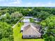 Wide aerial view of home with large lot, pool, surrounded by lush landscaping and mature trees, creating a private retreat at 8527 Firestone Cir, Clermont, FL 34711