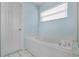 Bathroom featuring a large soaking tub next to a window and a tiled surround at 8527 Firestone Cir, Clermont, FL 34711
