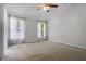Spacious bedroom with neutral carpet, ceiling fan, and bright windows at 8527 Firestone Cir, Clermont, FL 34711