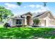 Beautiful single-story home with a well-maintained lawn, attached two-car garage and manicured landscaping at 8527 Firestone Cir, Clermont, FL 34711