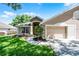 Charming single-story home featuring a well-manicured lawn, tasteful landscaping, and an attached two-car garage at 8527 Firestone Cir, Clermont, FL 34711