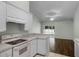 Bright kitchen features white cabinets, tile floors, and an open layout to the living area at 8527 Firestone Cir, Clermont, FL 34711