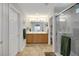 Well-lit bathroom featuring double sinks, a large mirror, and a glass-enclosed shower at 8652 Se 133Rd Ln, Summerfield, FL 34491