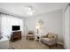 Comfortable bedroom with carpet floors, fan, and a reading corner near the window at 8652 Se 133Rd Ln, Summerfield, FL 34491